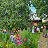 Menschen im Garten lauschen einer Sängerin